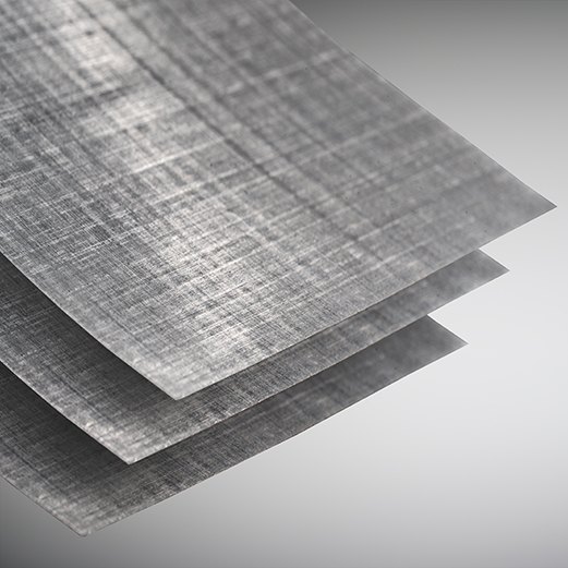 Close-up of three thin, gray composite sheets with a woven crosshatch texture, stacked.