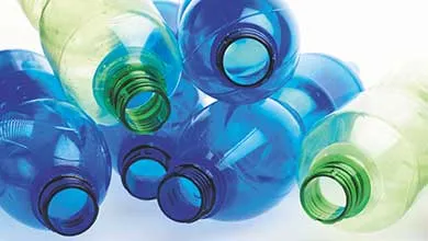 Close-up of empty blue and light green plastic bottles piled together.