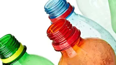 Close-up of the tops of several empty plastic bottles in green, orange, and blue.