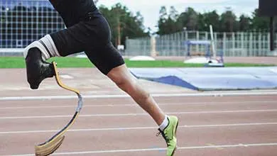 Track athlete mid‑stride using a curved composite running blade on an outdoor athletics track.