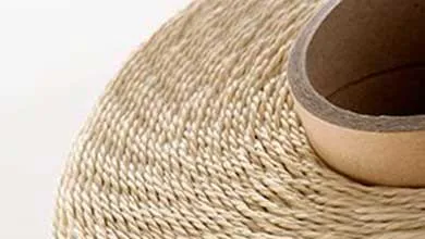 Close-up of natural beige sisal rope wound around a cardboard tube, showing its braided texture on a white background.